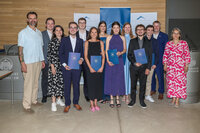 Foto: Eine Gruppe von Personen steht in einem Raum der Universität Hohenheim. Einige halten blaue Mappen mit dem Logo der Universität. Im Hintergrund sind Banner mit dem Logo der Universität sichtbar.